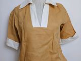 an image of a mannequin wearing a tan shirt with white collar