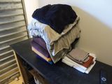 a stack of folded clothes on a table in a room