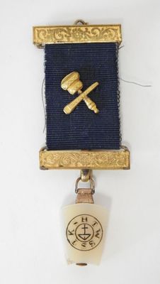 an image of a small badge with a hammer and a bell on it