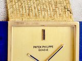 a close up of a gold wrist watch with a blue band