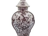 a vase that has a bird on top of it