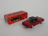 red toy car with black roof in front of a red box