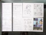 a man holding up a large sheet of paper with drawings on it