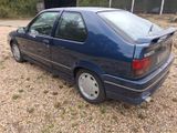 a picture of a blue car parked in a gravel lot
