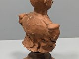an image of a clay bust of a child on a wooden base