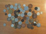 a pile of coins on a table next to a cell phone