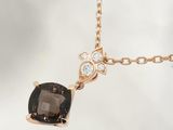 an image of a black and white diamond necklace with a gold chain