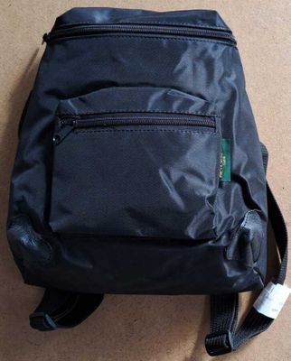 l'arrière d'un sac à dos noir posé sur un sol marron