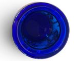 a blue glass bowl on a white surface