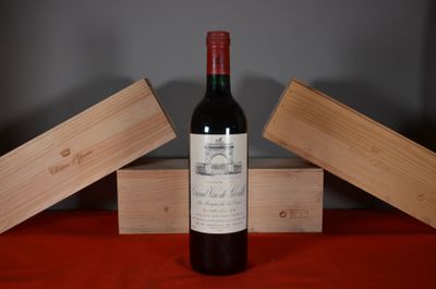 a bottle of wine sitting on a table next to two wooden boxes
