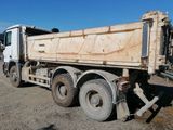 a dirty dump truck that is parked on the side of the road