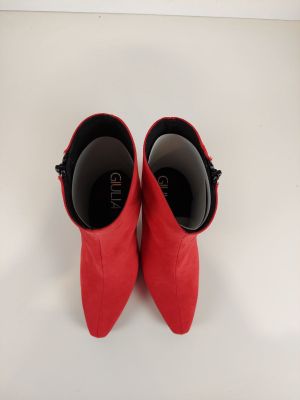 une paire de chaussures rouges posées sur une surface blanche, avec un fond blanc