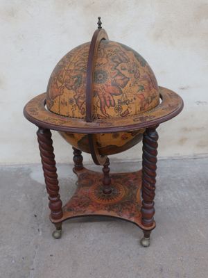 an old globe on a stand on the sidewalk