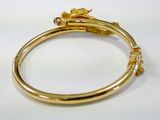 an image of a gold bang bracelet with a pink and yellow stone
