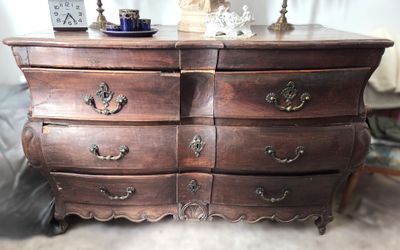 une commode en bois sur laquelle est posée une lampe