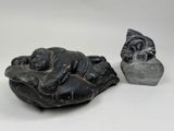 a small statue of a sleeping buddha next to a smaller statue of a sleeping buddha
