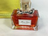 a small bottle of perfume with a bow on it