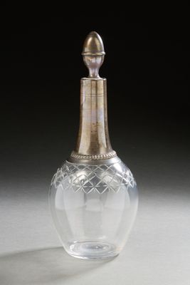 a clear glass bottle with a gold top on a table