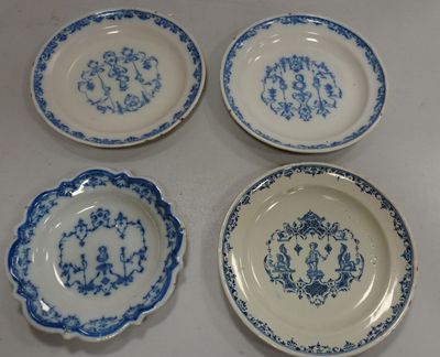 four blue and white plates with designs on them sitting on a table