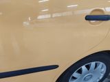 a yellow car that is parked in a parking lot