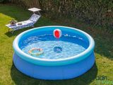 a small pool with a ball in it and a lawn chair in the background