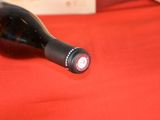 a bottle of wine sitting on a red cloth
