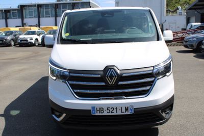la camionnette blanche est garée dans un parking avec d'autres voitures
