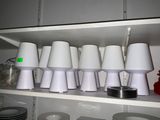 many cups and plates on a shelf in a kitchen