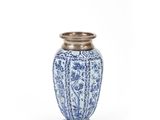 a blue and white vase sitting on top of a white table