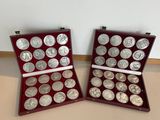 two boxes with silver coins in them on a table