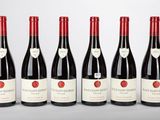 six bouteilles de vin rouge sont alignées