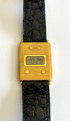 un gros plan d'une montre en or avec un bracelet noir