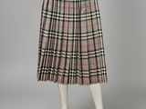 a woman wearing a skirt and sweater with a plaid pattern on it
