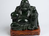 statue of a laughing buddha sitting on a wooden stand