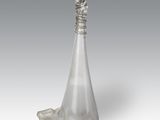 an image of a silver vase with a hand on top of it