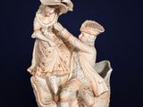 statue of a woman holding a child on a boat with a man sitting on it