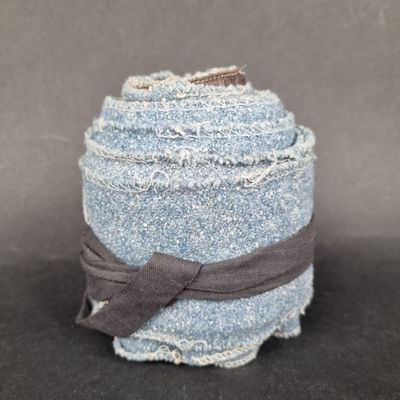 a stack of blue jeans wrapped in a brown ribbon