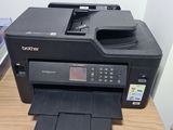 a black printer sitting on top of a wooden desk next to a printer