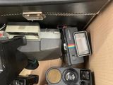 a box full of old cameras and other electronic equipment