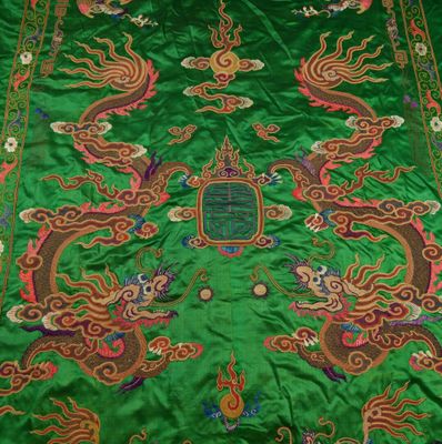 a close up of a green table cloth with a dragon design on it