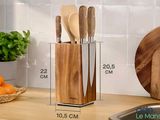des ustensiles et des couteaux en bois rangés dans un support en bois posé sur un plan de travail de cuisine