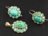 trois bijoux en turquoise et or posés sur un fond noir