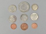 six different british coins are arranged in a circle on a gray surface