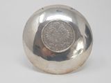 a silver ball with a coin in it
