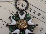 a small white star with a green and gold design on it