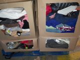 two cardboard boxes with clothes in them sitting on a pallet