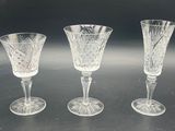 three glass goblets sitting on top of a table next to each other