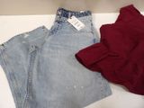 two pairs of jeans and a red shirt are on a table