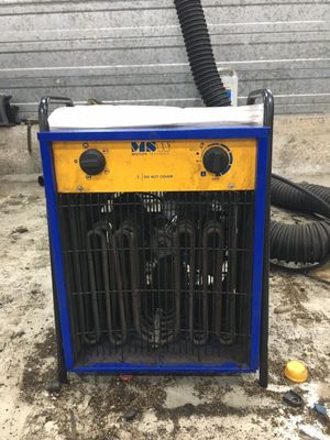 un radiateur électrique posé à même un sol sale, près d'un mur