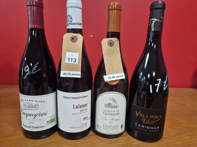 quatre bouteilles de vin sont alignées sur une table en bois